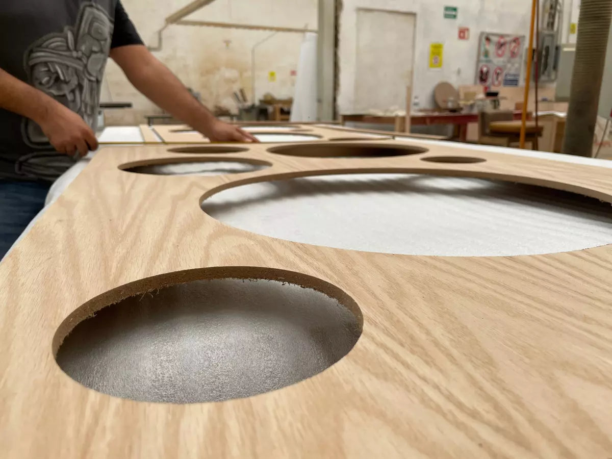 the hands of a person assembling a wood wall mirror