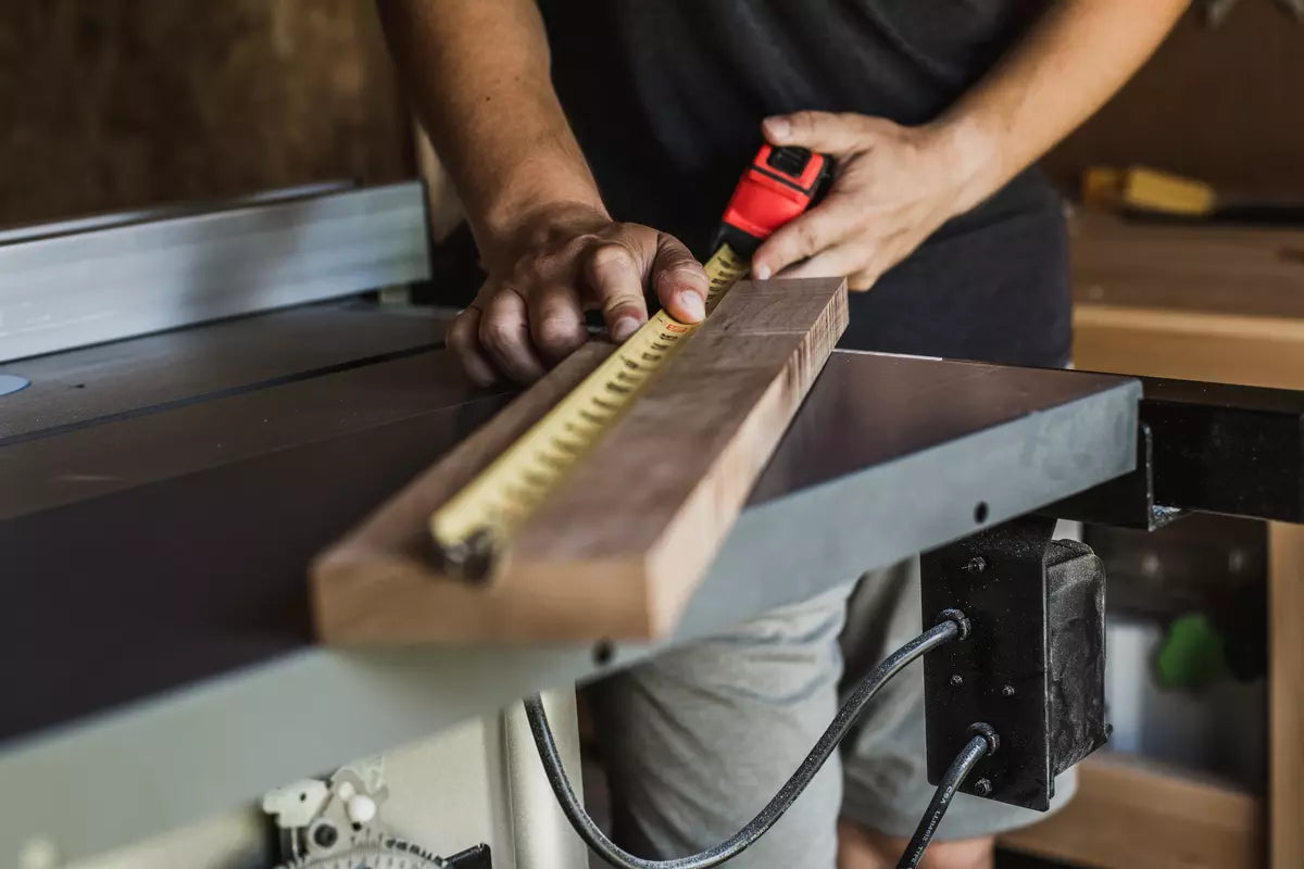 man measuring wood